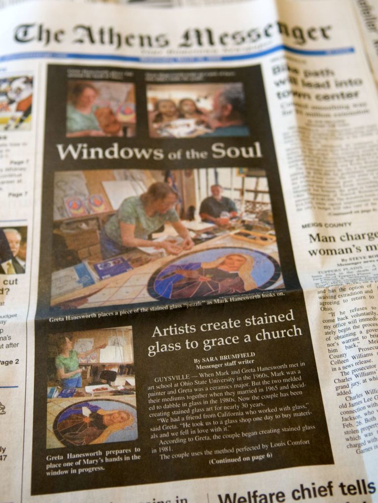 A photo of a newspaper featuring an article about Greta and Mark Hanesworth's stained glass.
