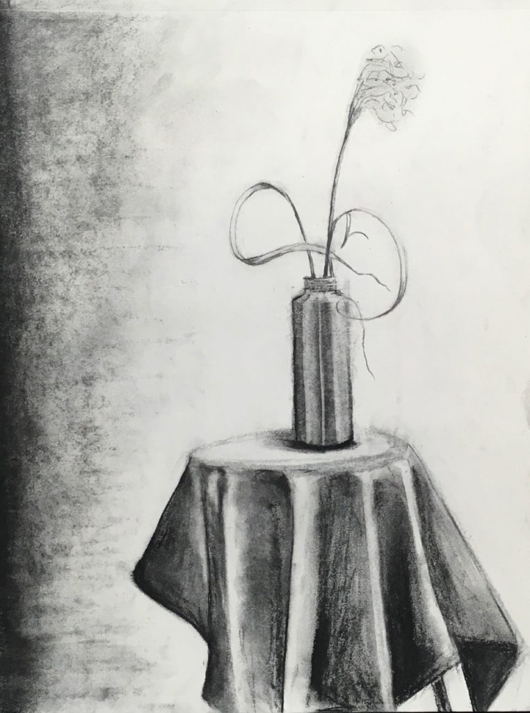A charcoal drawing of a cylindrical vase on small fabric covered table holding a stem of flowering grass.