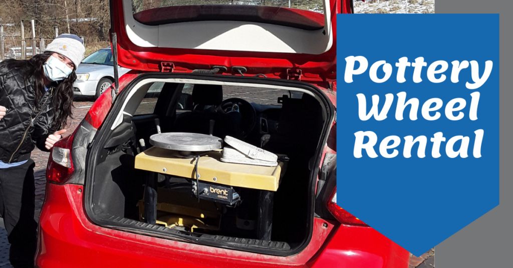 A pottery wheel is loaded in the back of a member artist's car. She is giving the thumb's up sign.